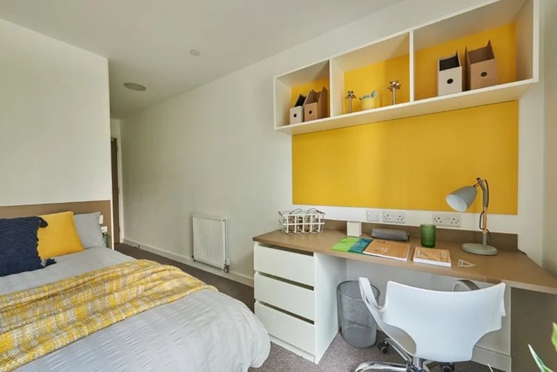 Bed desk and shelves with yellow accent bedroom study area at Grand Felda House in Wembley Student Accommodation