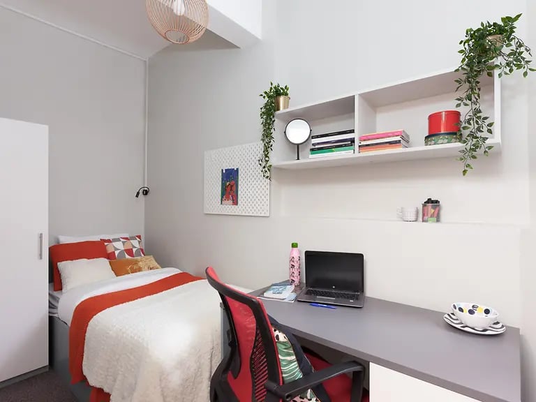 Bed desk chair and shelf bedroom study area at Louise House in London Student Accommodation