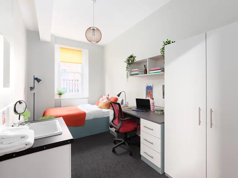 Bed desk sink and wardrobe bedroom study area at Louise House in London Student Accommodation