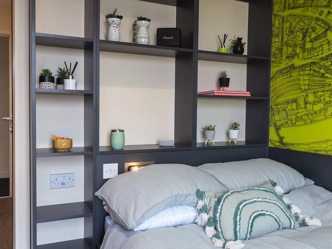 Bed with pillows shelves with decor bedroom at Oxford House - Newcastle in Newcastle Upon Tyne Student Accommodation