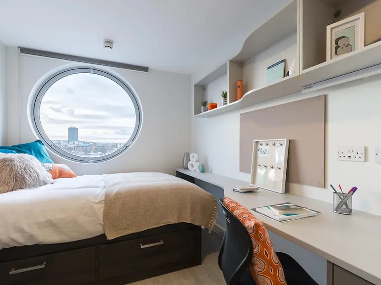 Bed desk and circular window bedroom at Livin Cardiff in Cardiff Student Accommodation