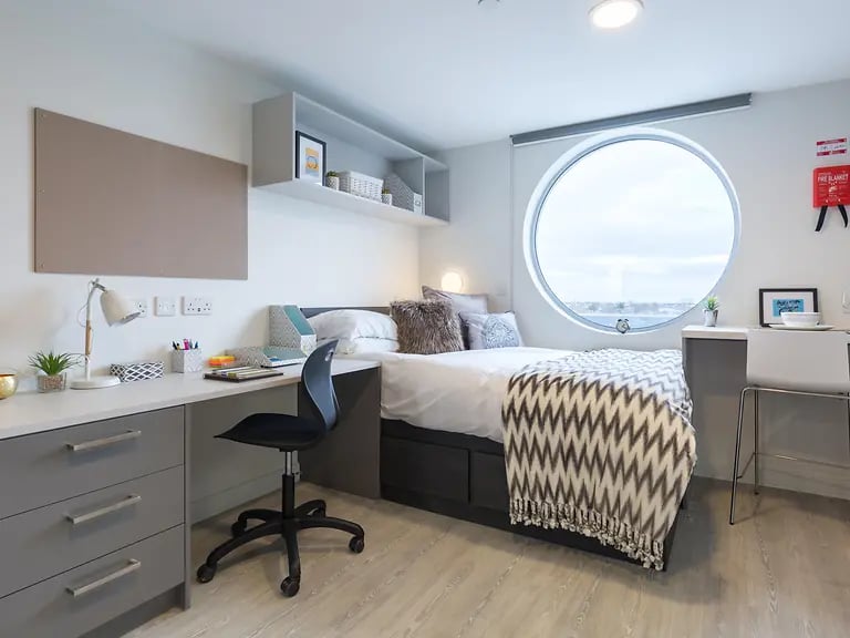 Bed desk chair pinboard circular window bedroom at Livin Cardiff in Cardiff Student Accommodation
