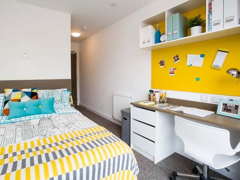 Bed desk pillows shelves and artwork bedroom at Felda House in Wembley Student Accommodation
