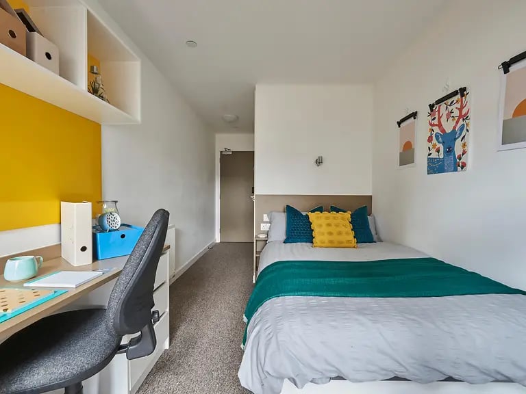 Bed desk shelving and posters bedroom at Felda House in Wembley Student Accommodation