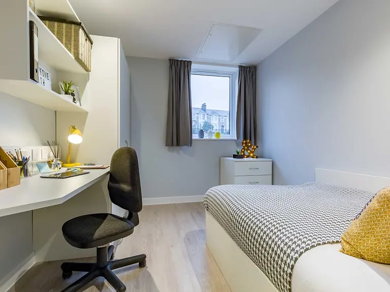 Desk chair bed shelves lamp dresser bedroom at Mary Parker House in Plymouth Student Accommodation