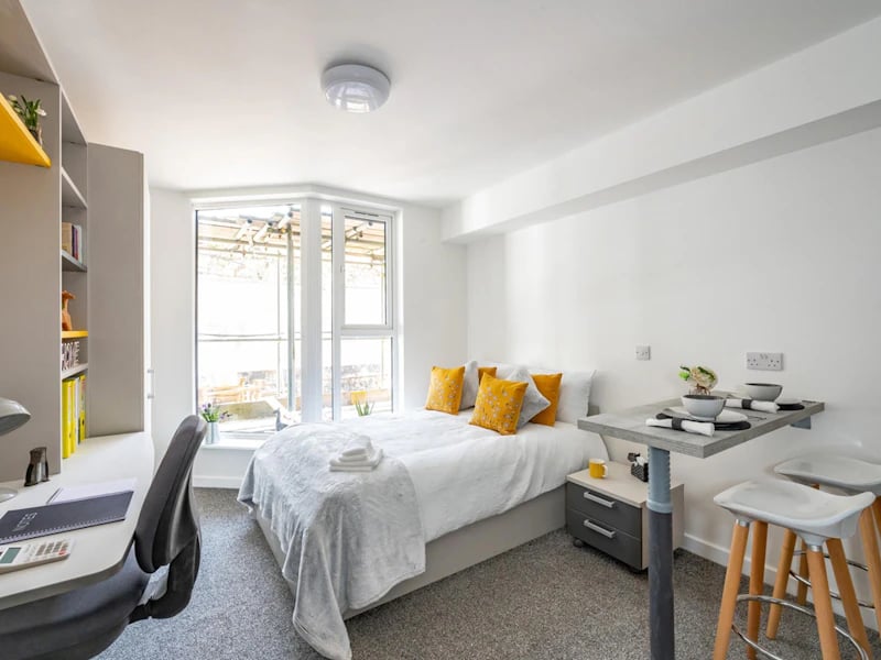 Bed desk shelving dining table and stools bedroom at Foundry Studios in Lancaster Student Accommodation