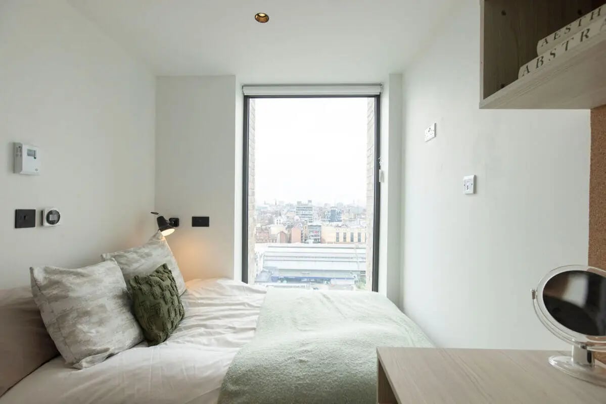 Bed with pillows blankets and desk mirror bedroom at Martha Street Apartments in Glasgow Student Accommodation