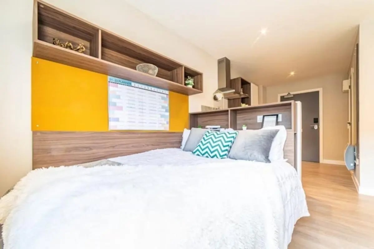 Bed with fluffy white duvet and patterned pillows bedroom at Brewer's Court in Edinburgh Student Accommodation