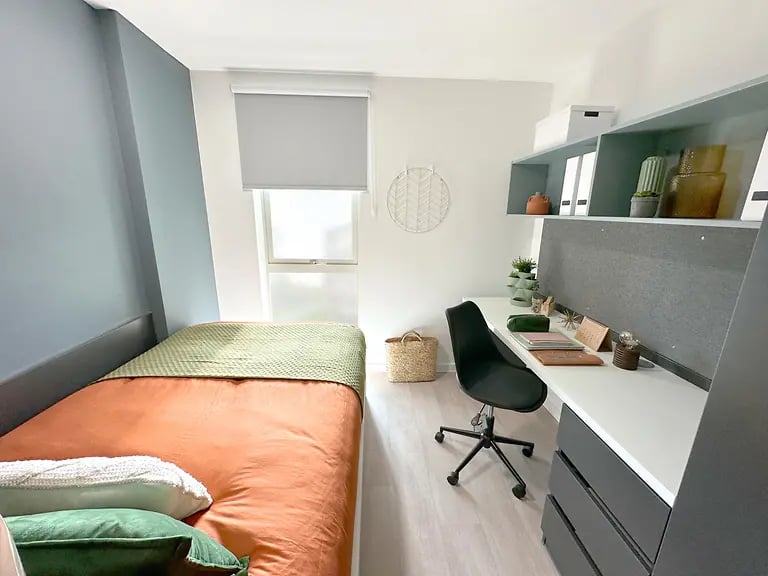 Bed desk chair and shelves bedroom study area at Enso in Colchester Student Accommodation