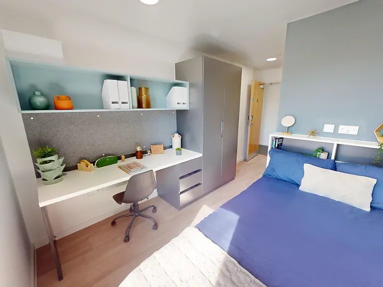 Desk bed wardrobe and shelves bedroom at Enso in Colchester Student Accommodation