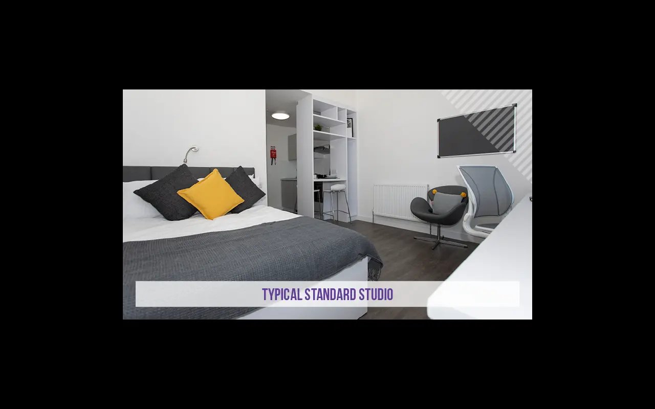Bed with pillows kitchen area chair studio at Kensington House in Birmingham Student Accommodation