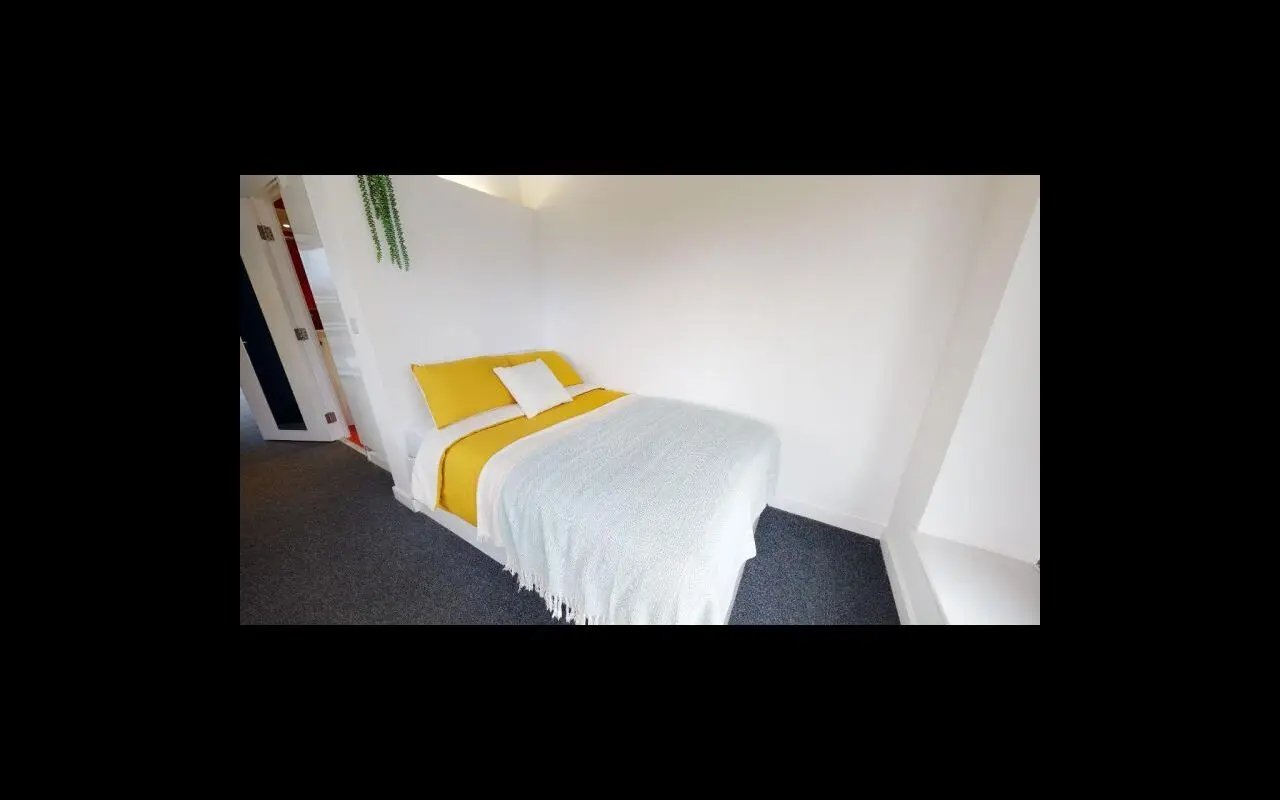 Bed with yellow bedding and white blanket bedroom at iQ Flinders House in London Student Accommodation