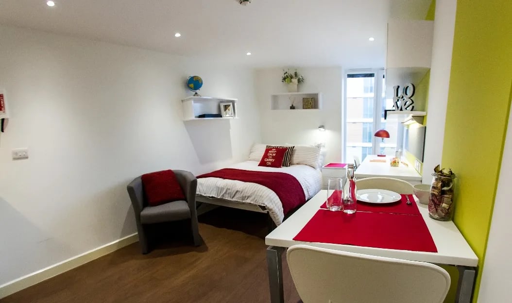Bed chair desk and table bedroom living area at Griffon Studios in London Student Accommodation
