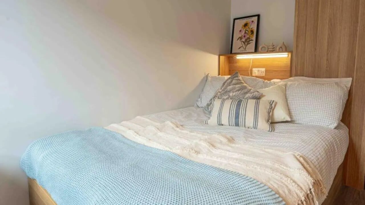Bed with pillows artwork above bedroom at iQ Sterling Court in London Student Accommodation