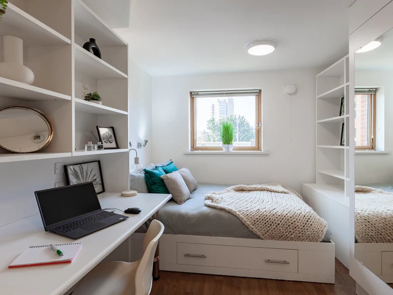 White shelving desk bed pillows window bedroom at Academic House in London Student Accommodation