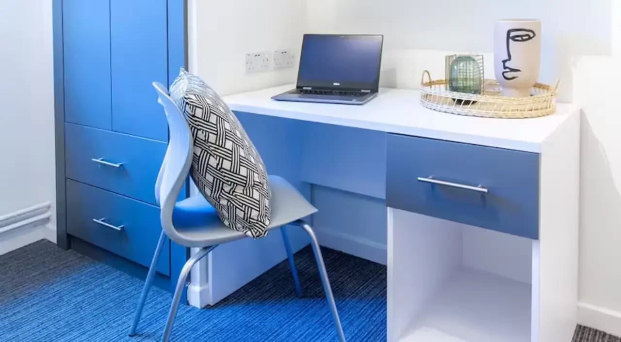 Blue wardrobe desk laptop chair cushion study area at Green Wood Court in Southampton Student Accommodation