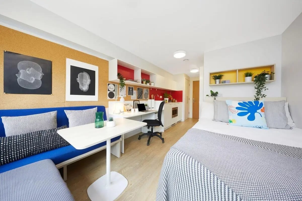 Bed desk sofa and kitchen studio bedroom at Collegiate Park House in Southampton Student Accommodation