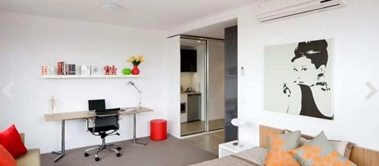 Desk chair laptop art and small kitchen studio apartment at Student Living D2 in Melbourne Student Accommodation
