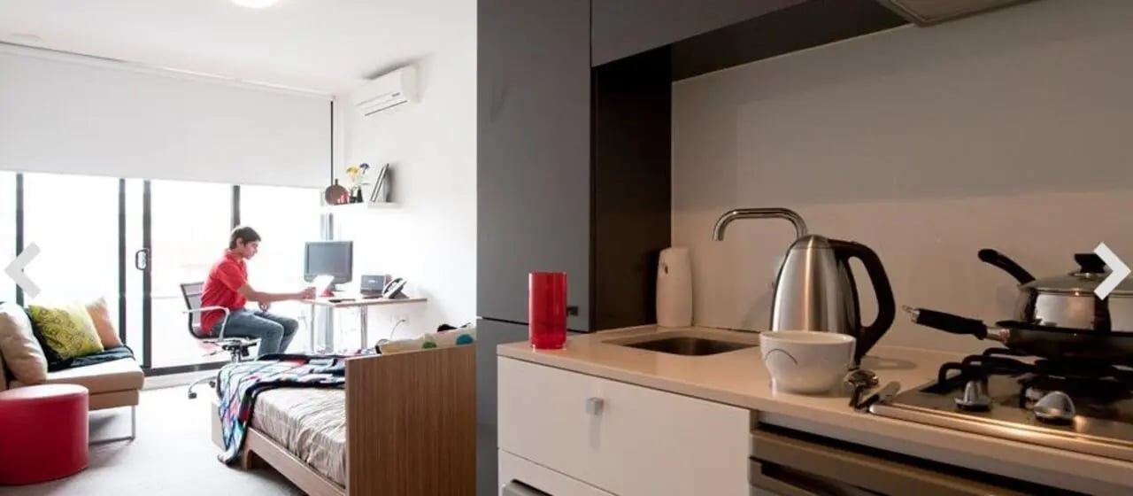 Desk bed sofa kettle stove kitchen living room at Student Living D2 in Melbourne Student Accommodation