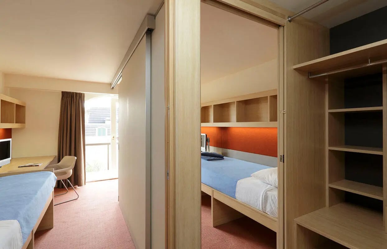 Bed desk chair and closet student bedroom at dwell Village Melbourne City in Melbourne Student Accommodation