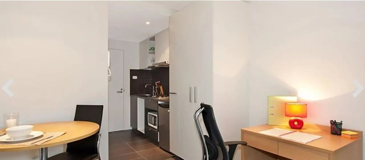 Desk chair round table and small kitchen living area at Student Living on Villiers in Melbourne Student Accommodation