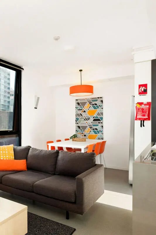 Sofa dining table chairs artwork living room at Iglu Central in Sydney Student Accommodation