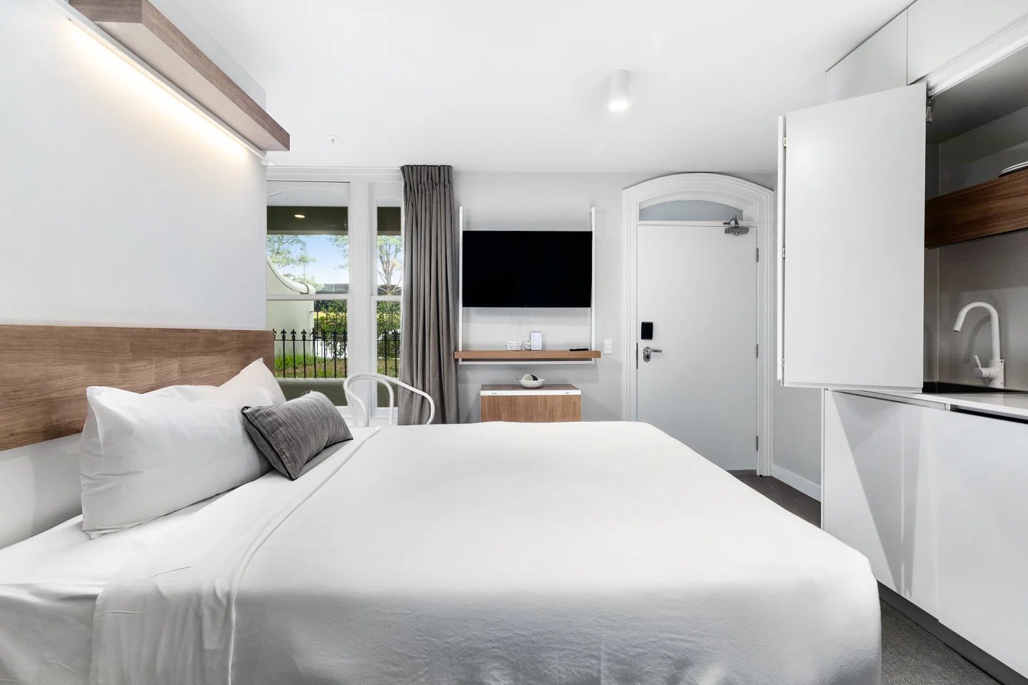 Bed TV kitchen and door Bedroom at UKO Paddington in Sydney Student Accommodation