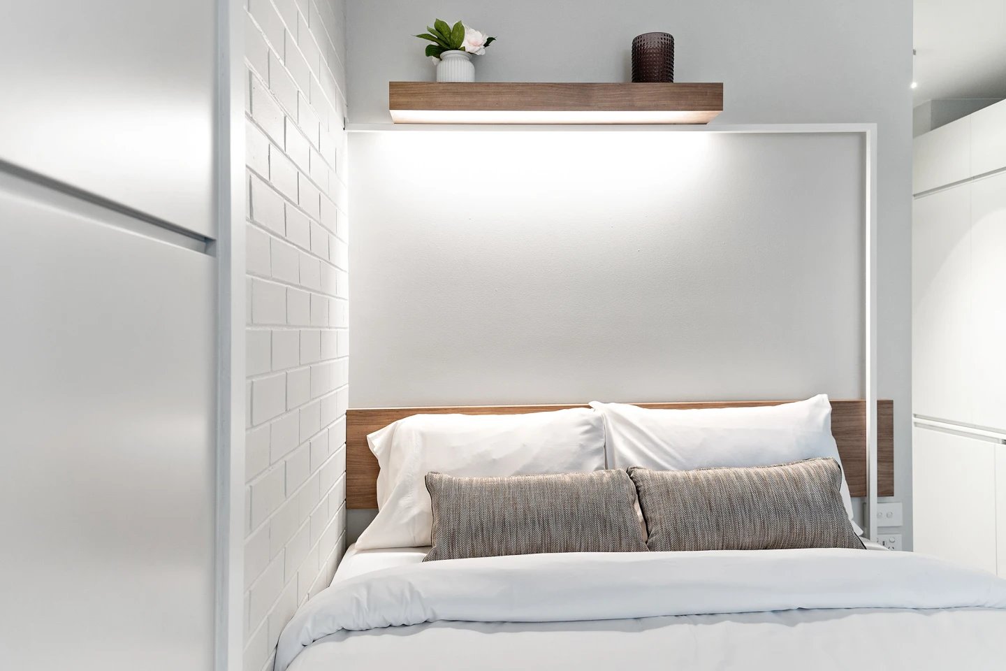 Bed with white linens and decorative pillows bedroom at UKO Paddington in Sydney Student Accommodation