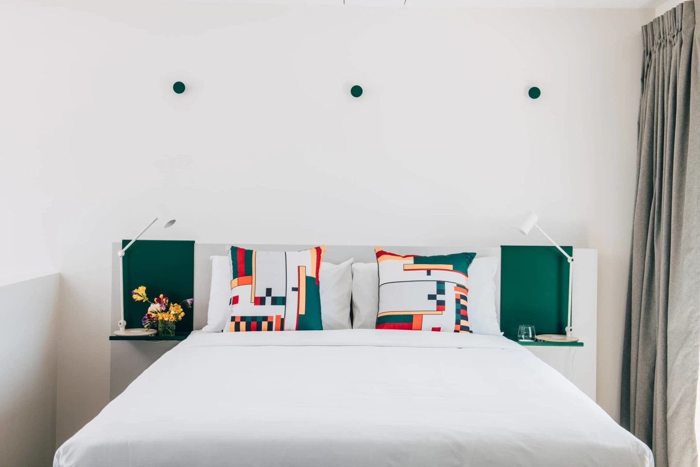 Bed with two decorative pillows and bedside lamps bedroom at UKO Stanmore in Sydney Student Accommodation