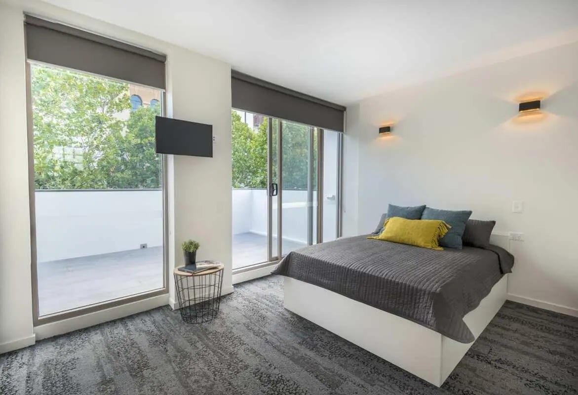 Bed with pillows and wall lights Bedroom at UKO Surry Hills in Sydney Student Accommodation