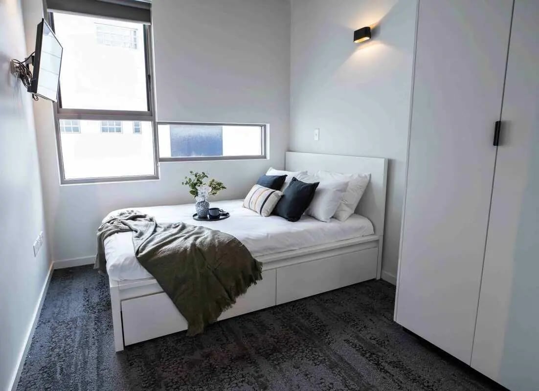 Bed with pillows and blanket white wardrobe bedroom at UKO Surry Hills in Sydney Student Accommodation