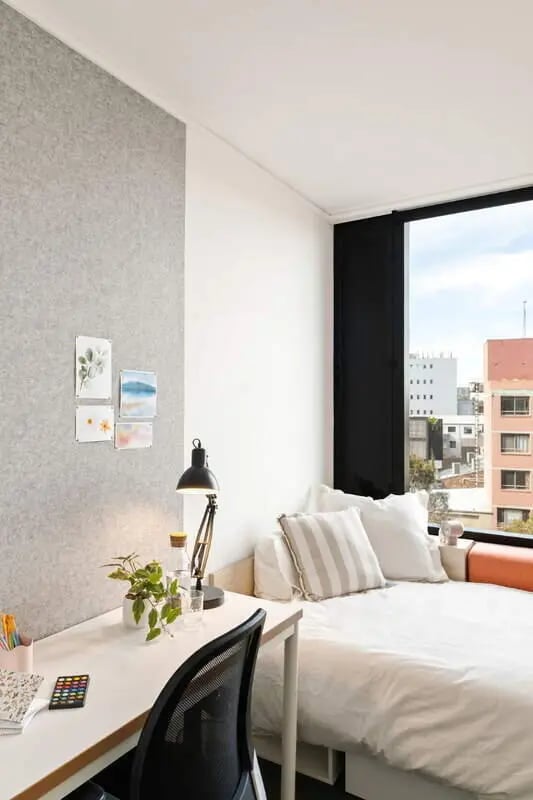 Desk with lamp and bed with pillows bedroom at Iglu Redfern in Sydney Student Accommodation
