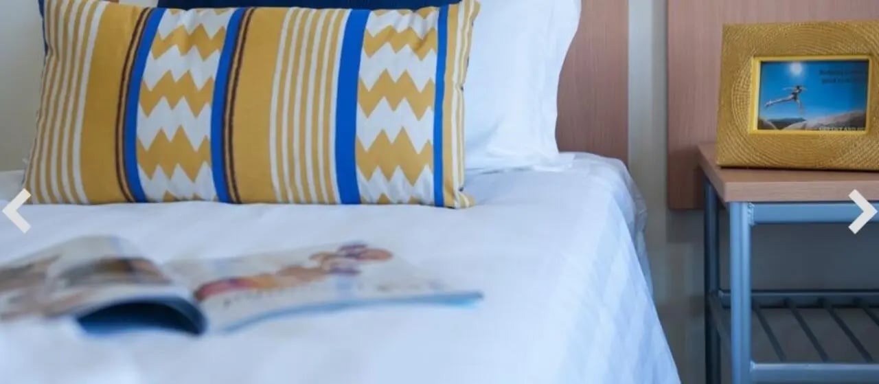 Bed with patterned pillow and framed photo bedroom at Student Living-590 Lygon in Melbourne Student Accommodation
