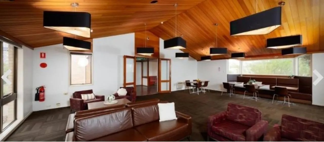 Leather couches and chairs with dining tables living room at UniLodge @ UC - Campus West & Guginya in Canberra Student Accommodation