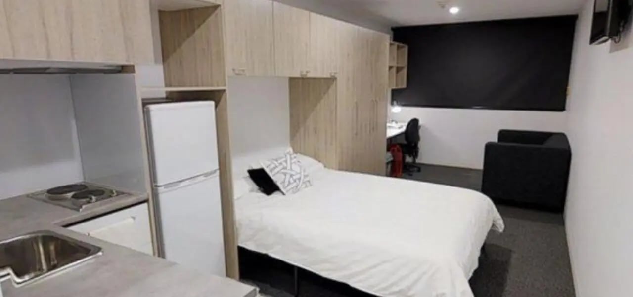 Bed fridge kitchen sink desk sofa bedroom at Unilodge South Bank in Brisbane Student Accommodation