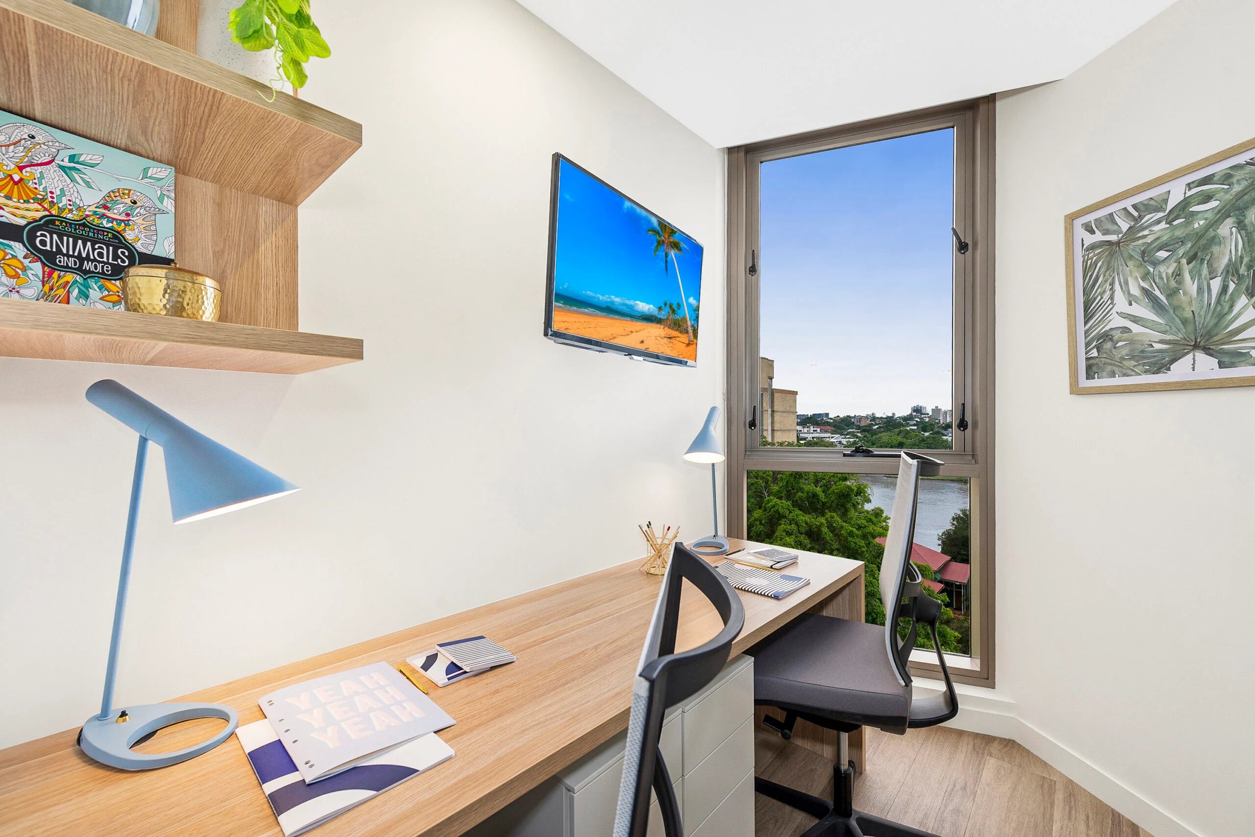 Desk lamp coloring book chairs TV window view study area at Scape St Lucia in Brisbane Student Accommodation