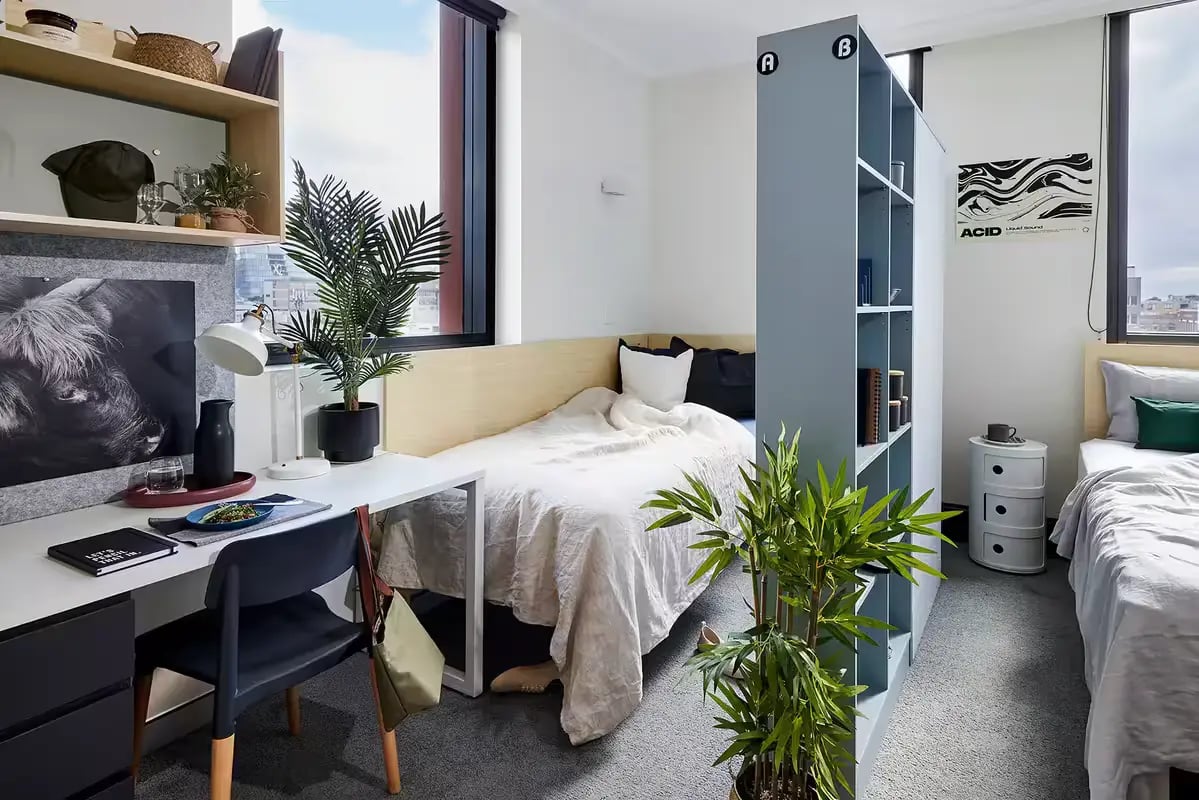 Beds desk chair plants bookshelf bedroom at Scape Darling Square in Sydney Student Accommodation