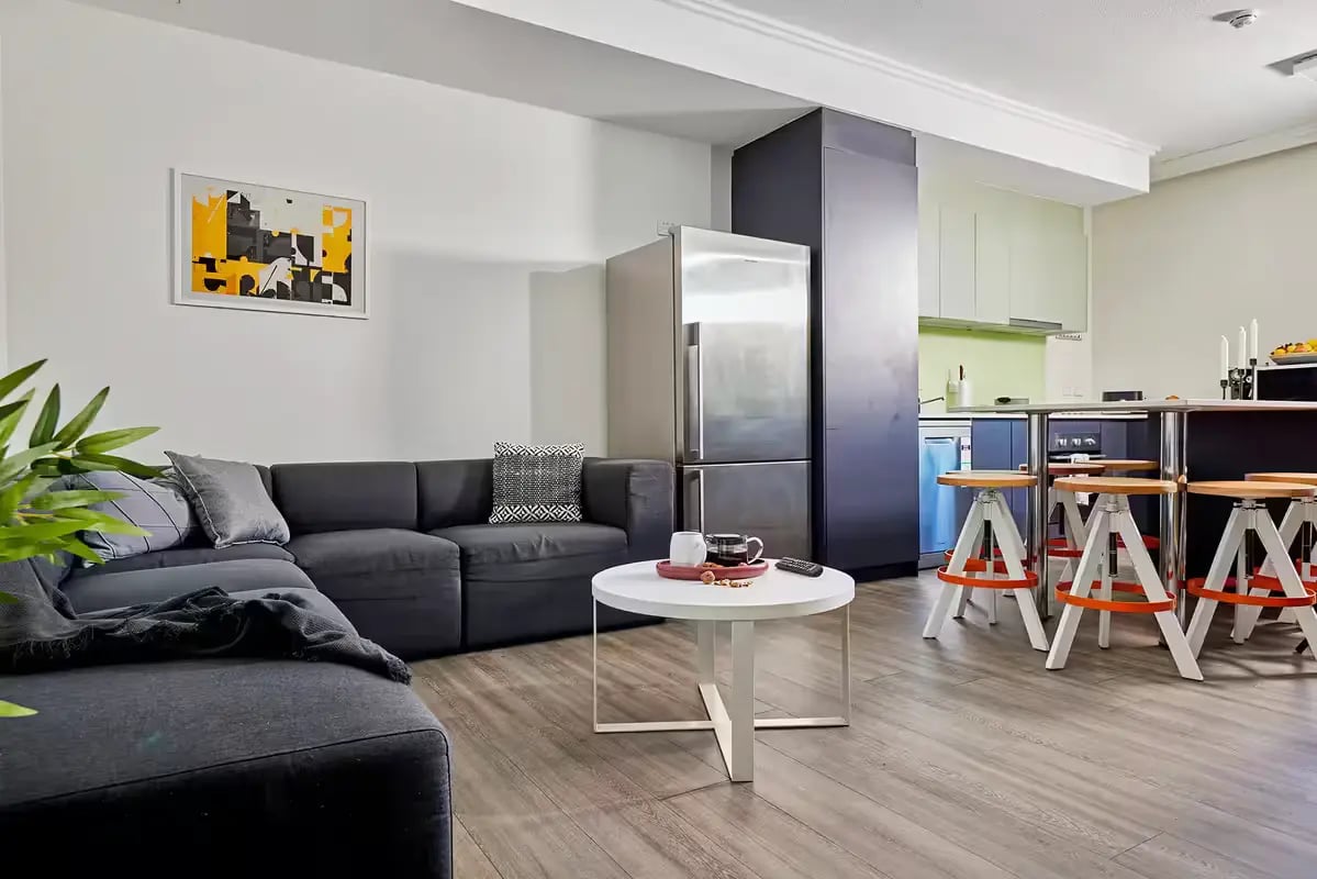 Modern sectional sofa coffee table and kitchen living room at Scape Darling Square in Sydney Student Accommodation