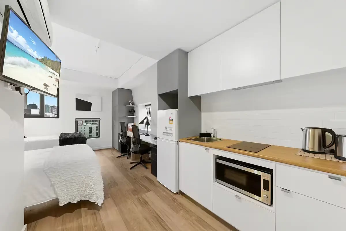 Beds desks fridge microwave and kitchen area studio apartment at Scape Waymouth in Adelaide Student Accommodation