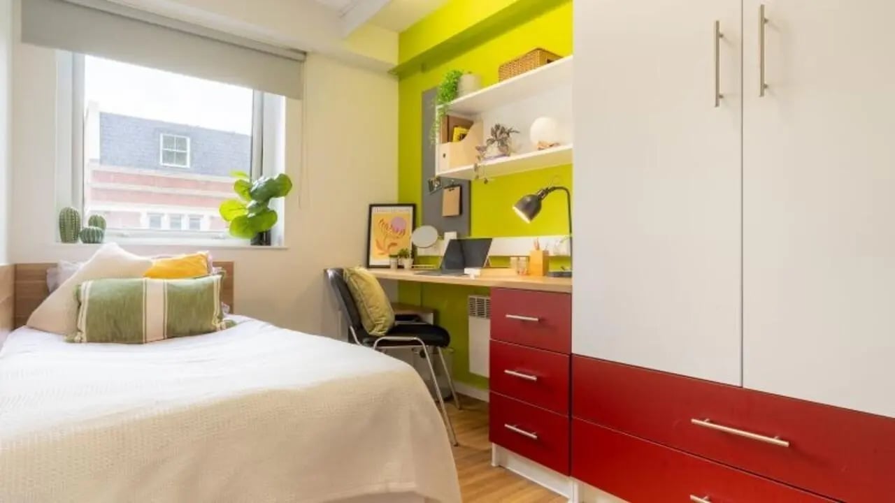 Bed desk lamp laptop cactus plants wardrobe bedroom at iQ The Arcade in London Student Accommodation