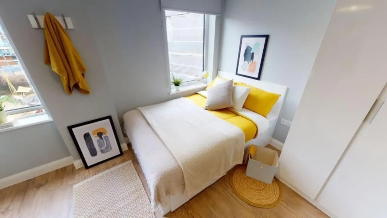 Bed with yellow bedding and artwork bedroom at iQ The Brickworks in York Student Accommodation
