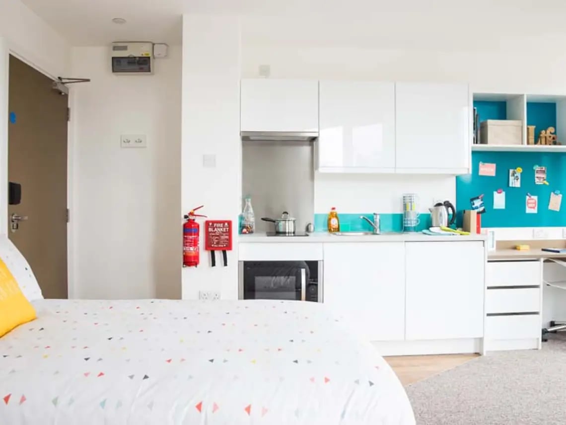 Bed kitchen area with appliances and fire safety equipment interior at Felda House in Wembley Student Accommodation