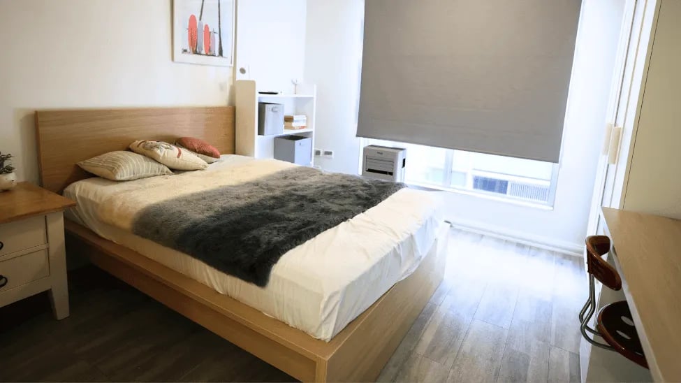 Bed with pillows blanket bedside table and artwork bedroom at Student Living - Shafston in Brisbane Student Accommodation