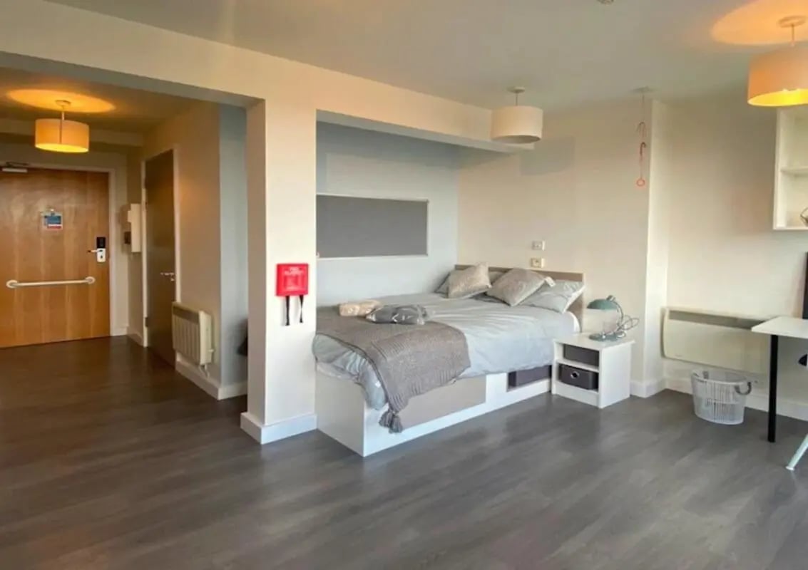 Bed pillows blanket bedside table whiteboard bedroom at Charles Morton Court in London Student Accommodation