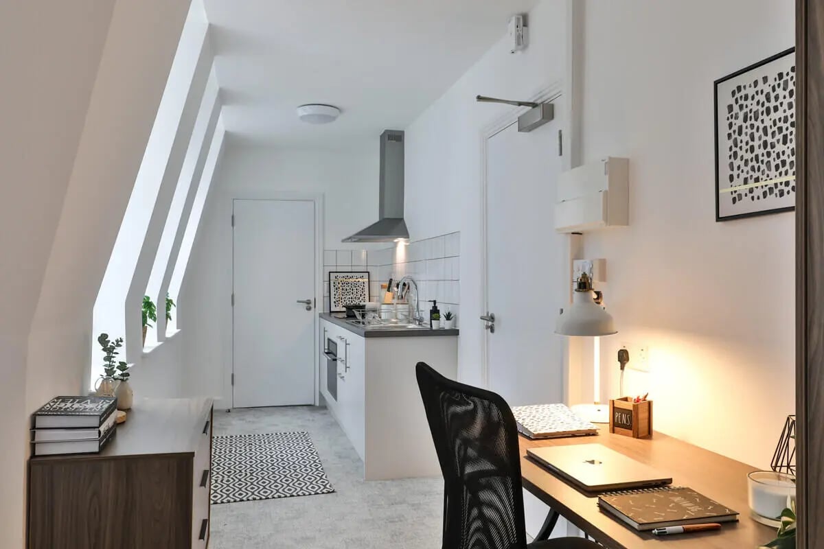 Desk chair kitchen counter desk and plants studio apartment at Francis Gardner in London Student Accommodation