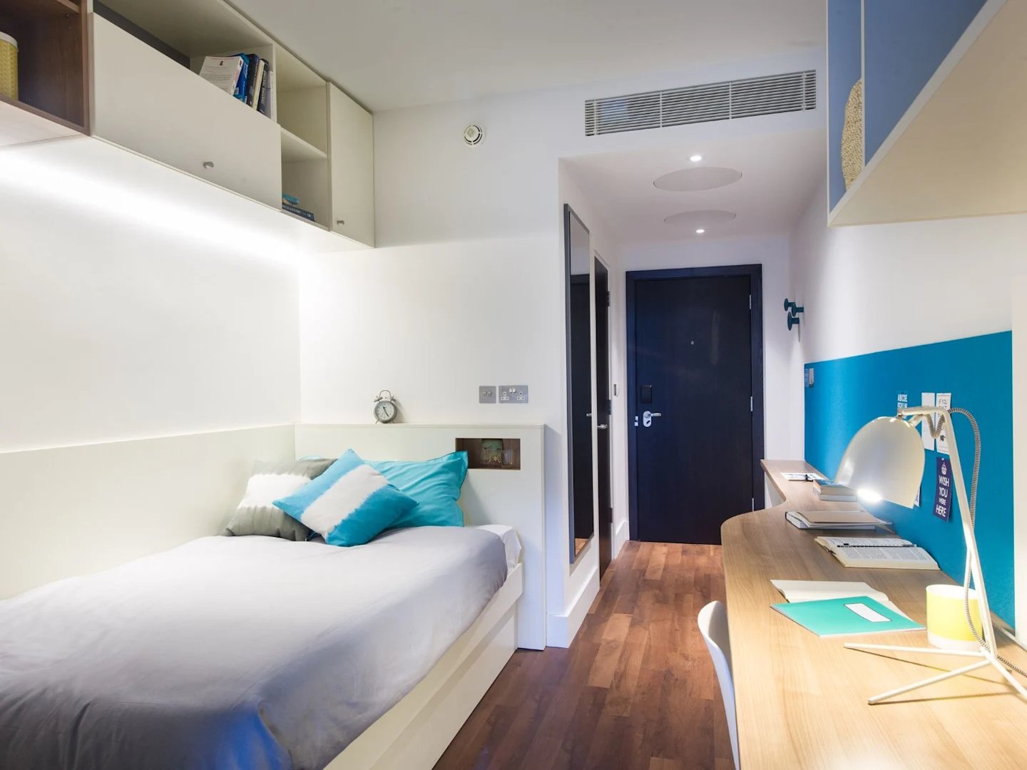 Bed desk and shelves student bedroom at Spring Mews in London Student Accommodation