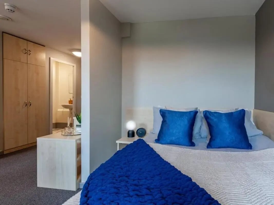 Bed with blue pillows and wardrobe bedroom at Crown House - Reading in Reading Student Accommodation