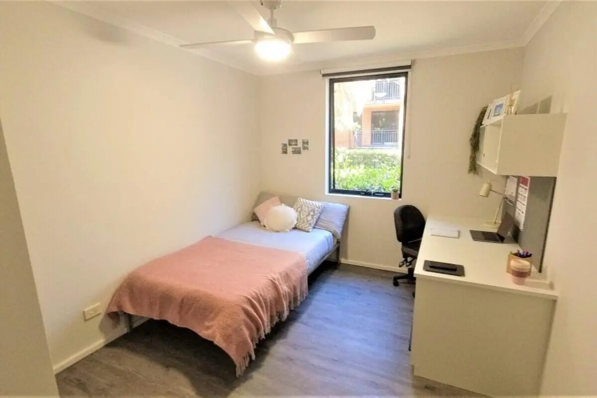 Bed desk chair and window student bedroom at Sydney University Village in Sydney Student Accommodation