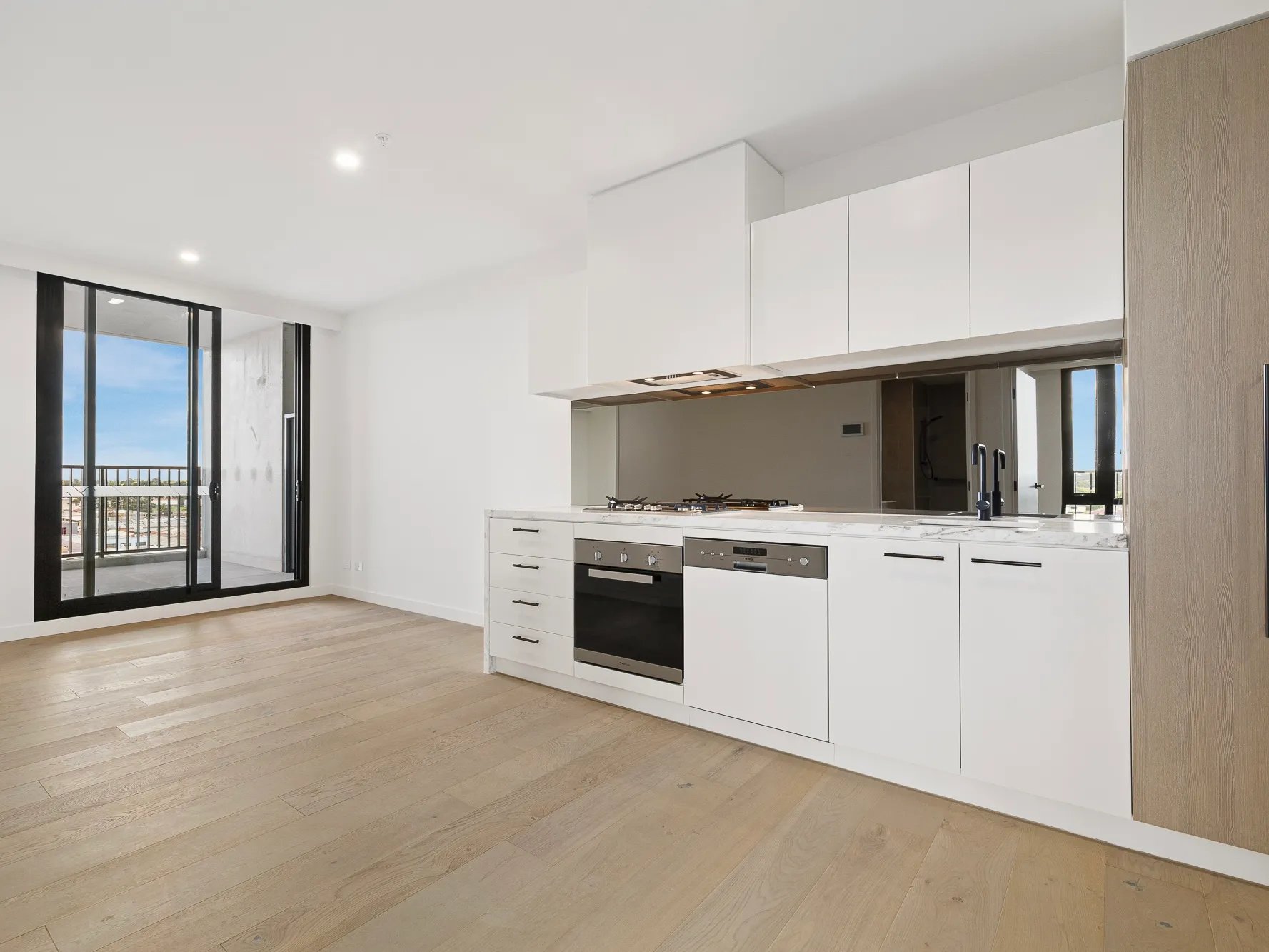 Modern white kitchen with oven dishwasher and balcony kitchen at BELONG Clayton Melbourne in Melbourne Student Accommodation