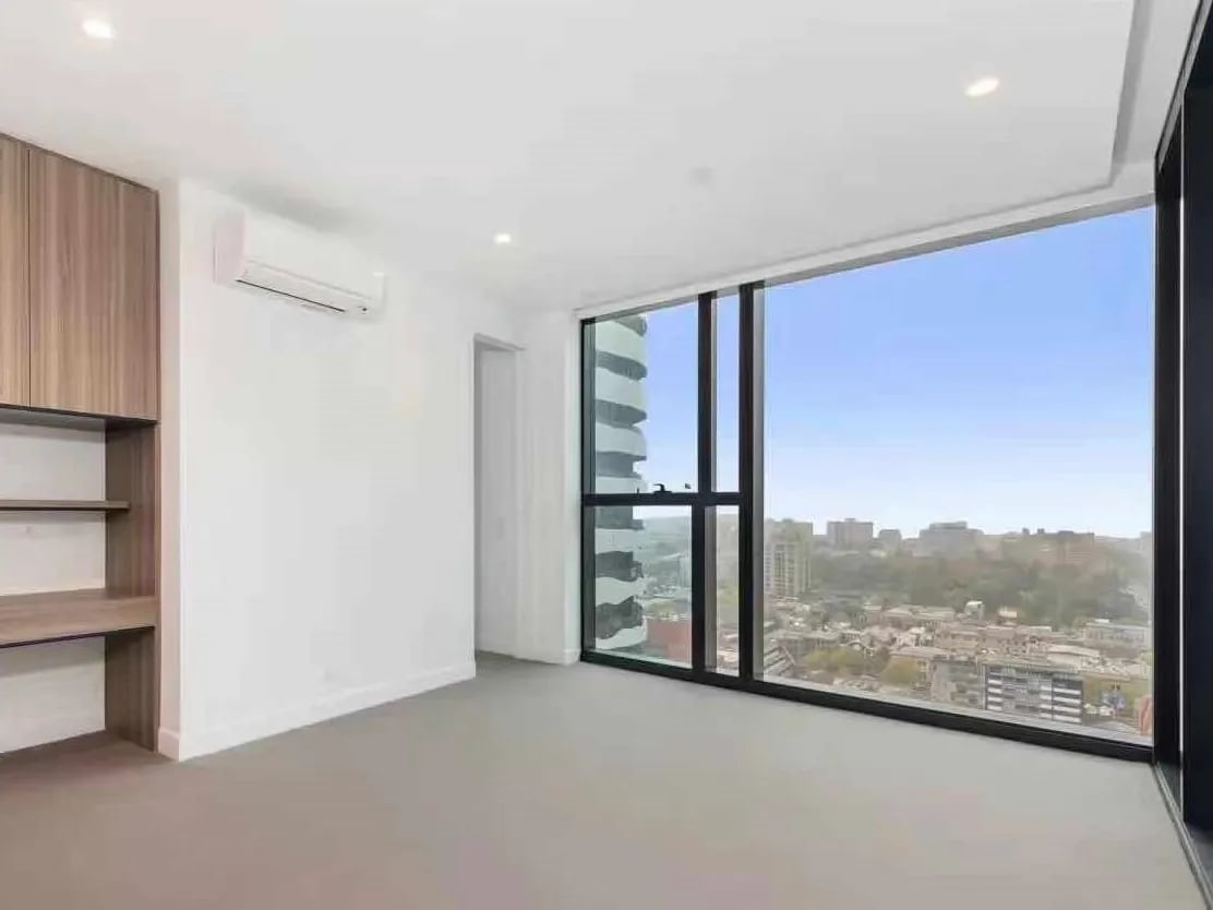 Built-in desk and shelves with city view bedroom at Belong Melbourne CBD in Melbourne Student Accommodation